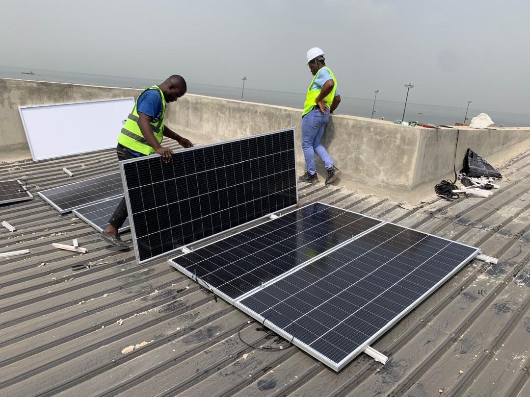 MOJATECH technicians fitting solar panels on a rooftop on Ibeshe Road